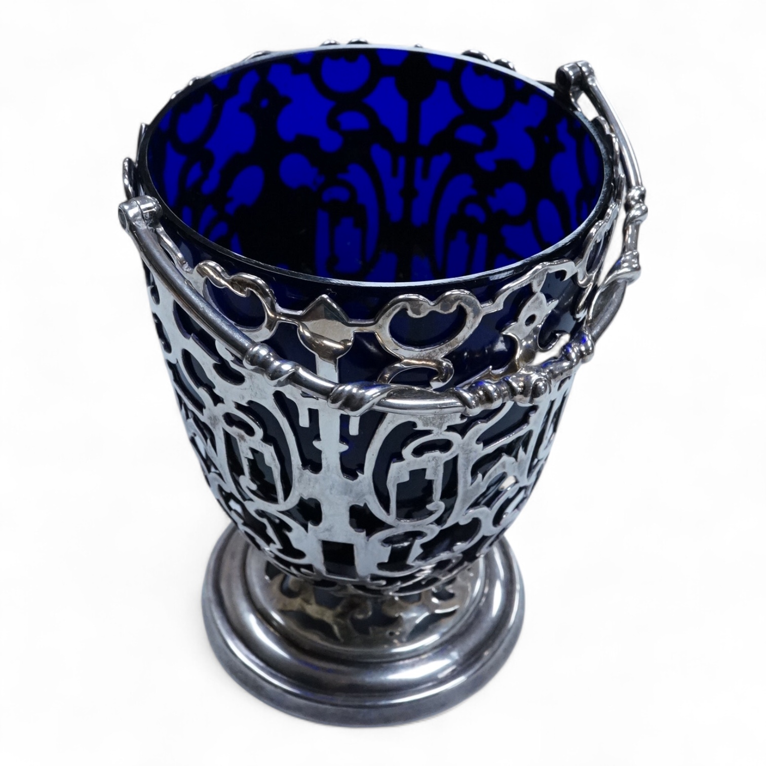 A Victorian pierced silver sugar basket with blue glass liner, makers mark rubbed, London, 1851, height excluding handle, 13.2cm, 7.9oz.